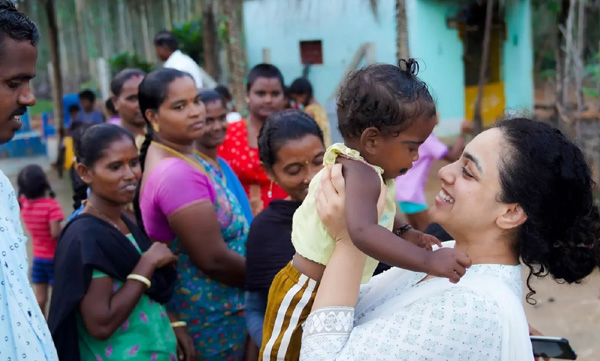 Nithya menon's picture of  carrying the children of village  is gaining praise from fans