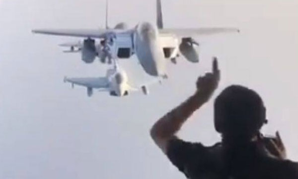A photographer poses for a photo of fighter jets