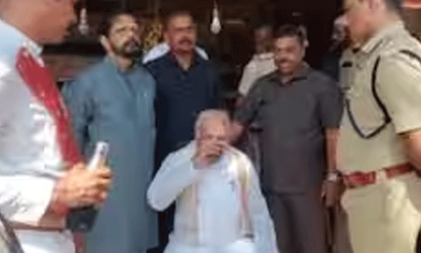 Kerala Governor sitting on a chair on the roadside against the black flag protest