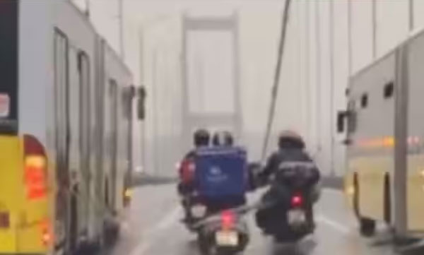 video-of-two-buses-helping-a-delivery-boy-cross-the-bridge-from-a-raging-storm-has-gone-viral