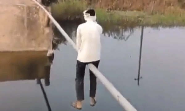 പാലം തകര്ന്നു: ഇരുമ്പുപൈപ്പിലിരുന്ന് പുഴ കടക്കുന്ന മനുഷ്യന്, വൈറലായി വീഡിയോ