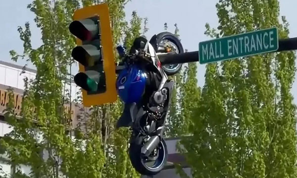motorcycle dangling from traffic light after biker crashes